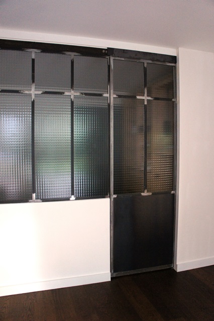 Porte coulissante en acier atelier d'artiste et verrière avec verre armé grande maille