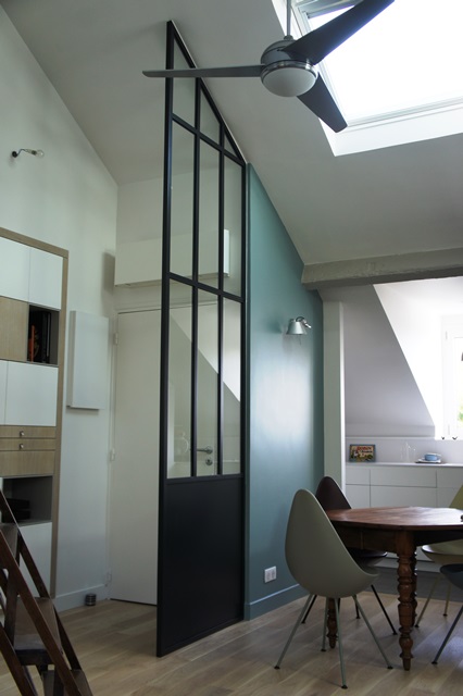 Verrière sous toiture dans un studio pour séparer une entrée d'un espace cuisine